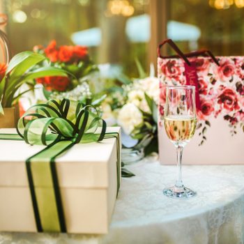 wedding gift table at a wedding, glass of champagne next to the gifts