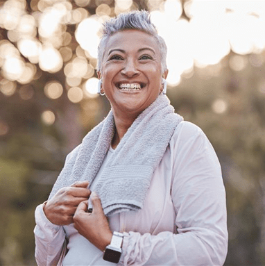 Woman looking up and smiling with short hair and towel around her neck 