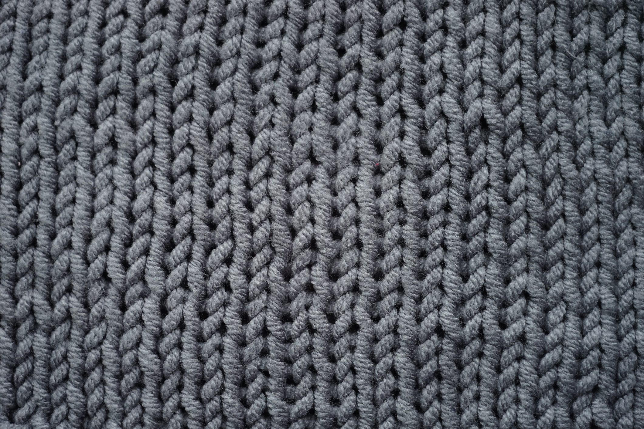 Knitted grey background, gray sweater cozy pattern