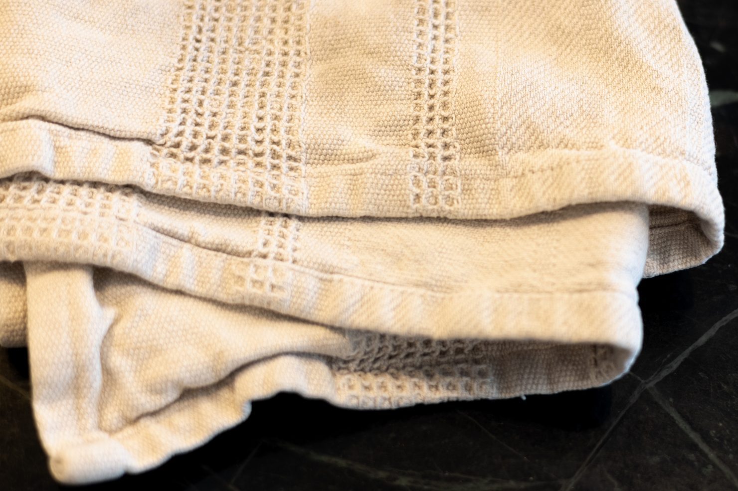 folded white dish towel on kitchen countertop