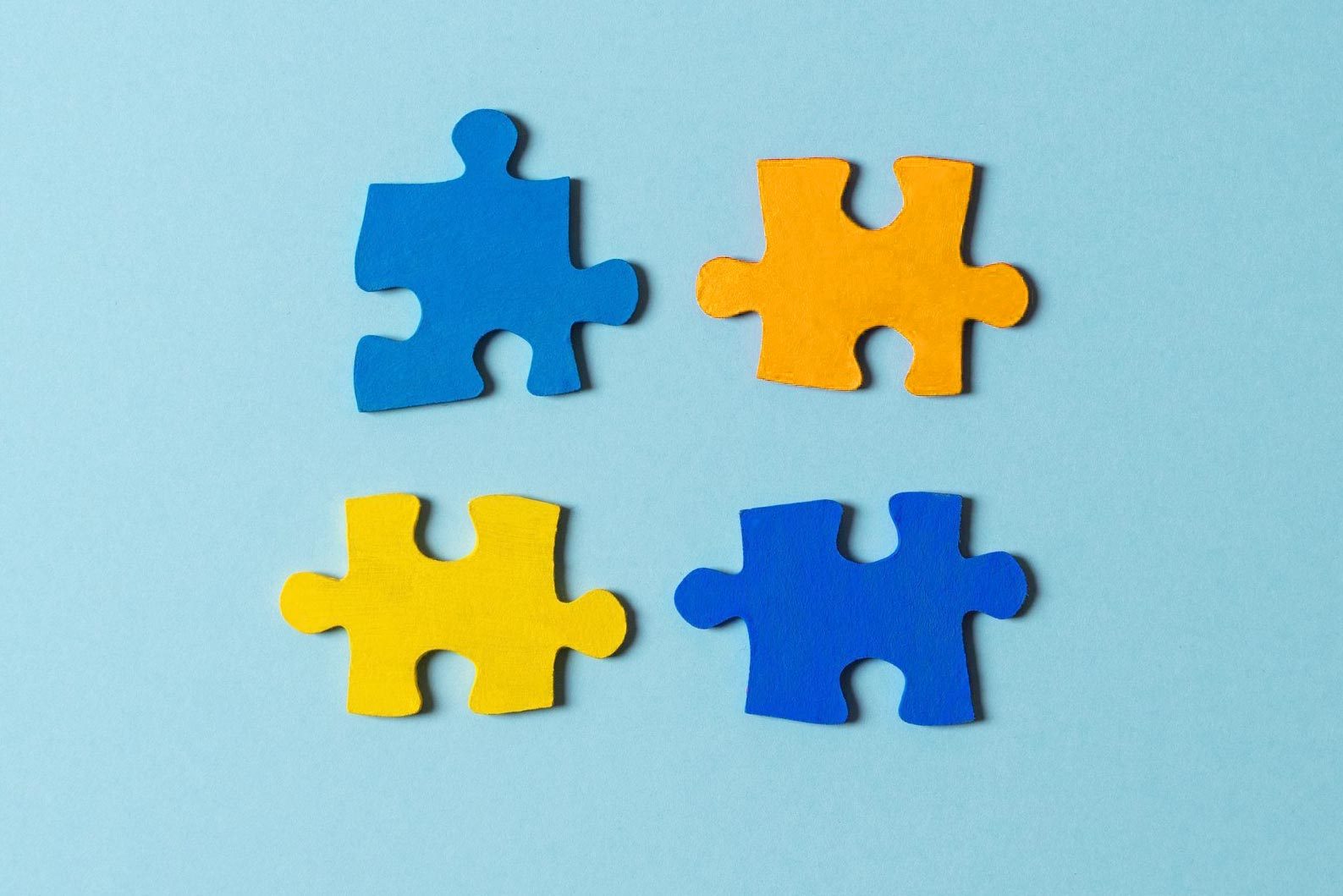 Blue, yellow, red pieces of puzzle on light blue background