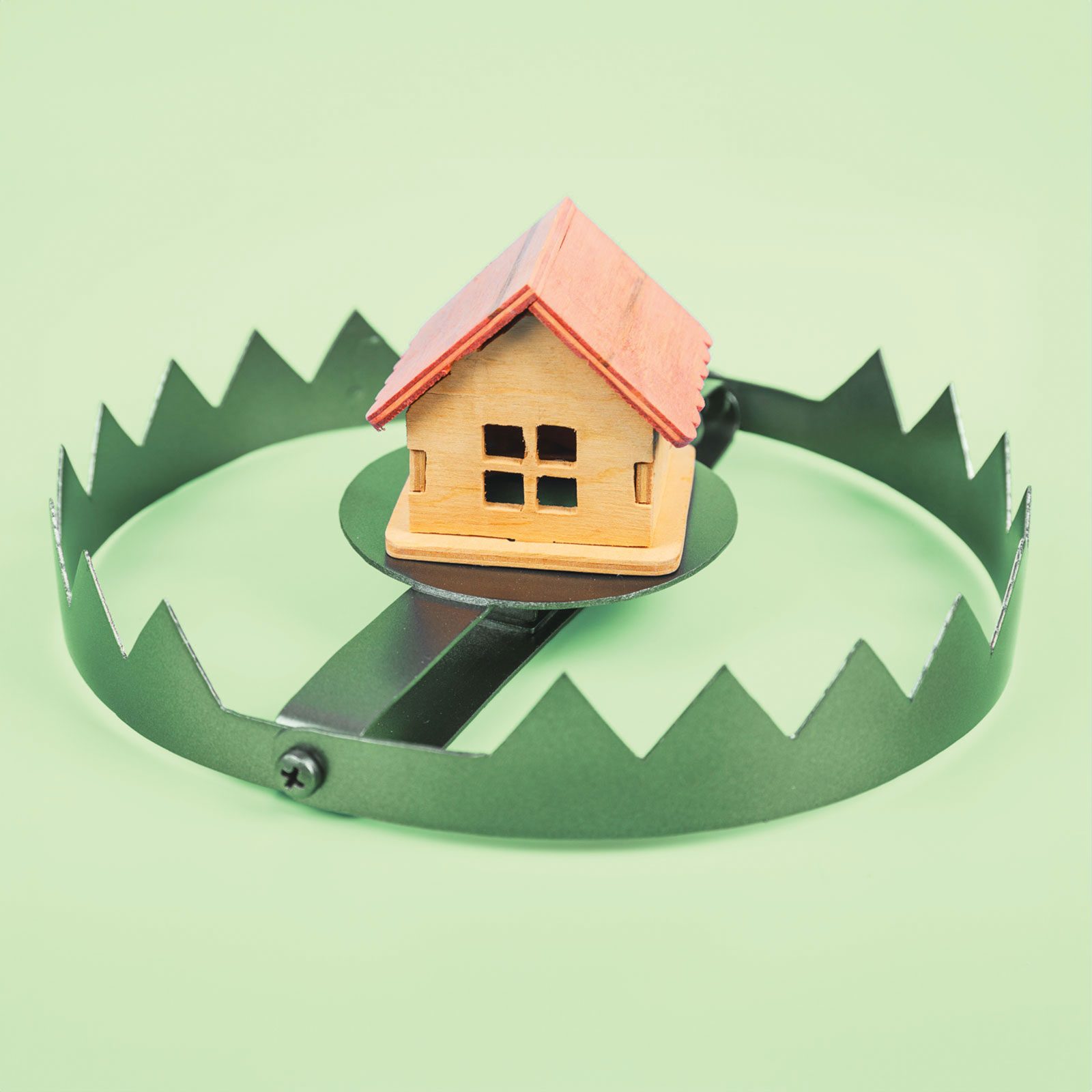 model house in a trap on a green background to represent rental scams