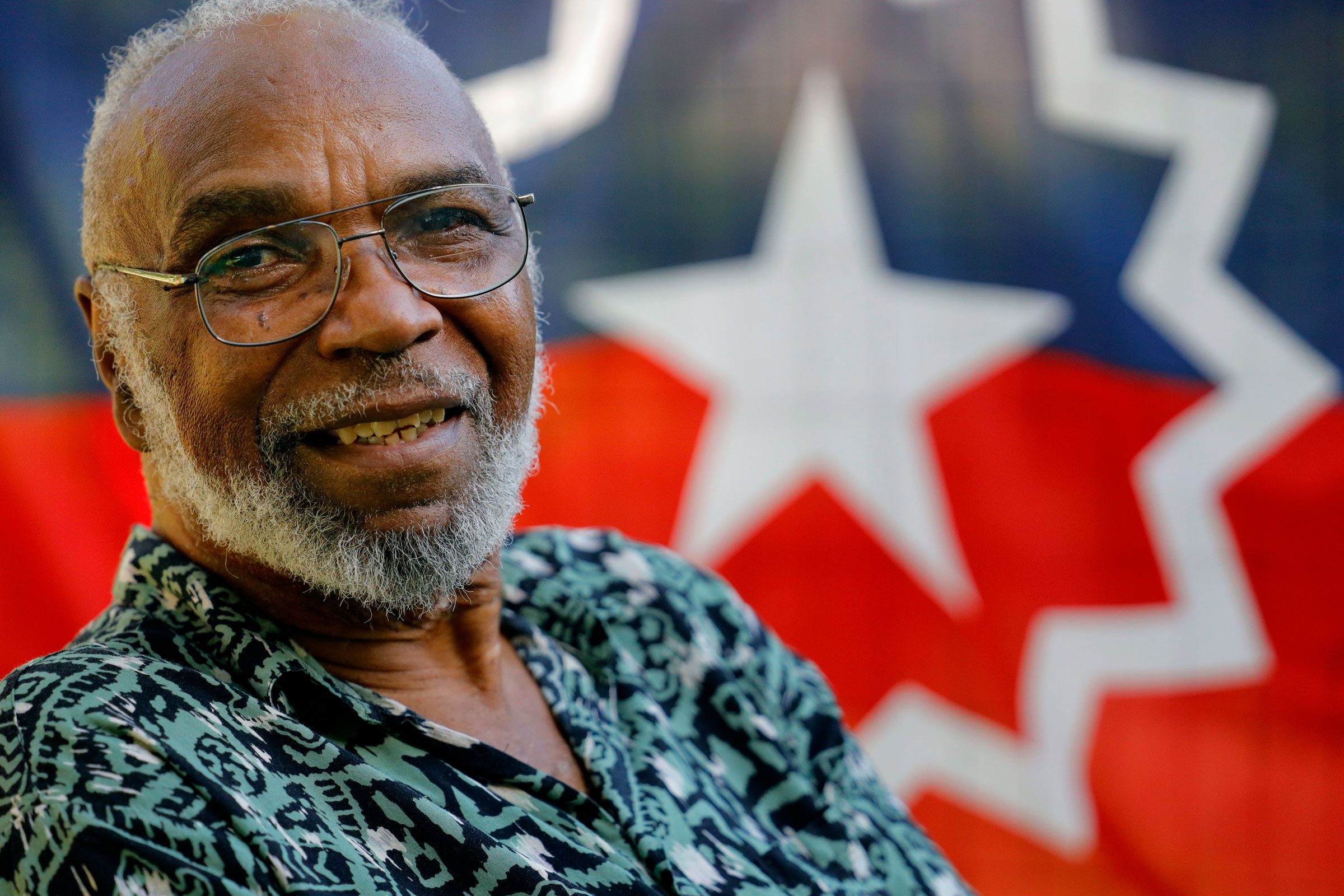Ben Haith poses for a portrait with a Juneteenth flag,