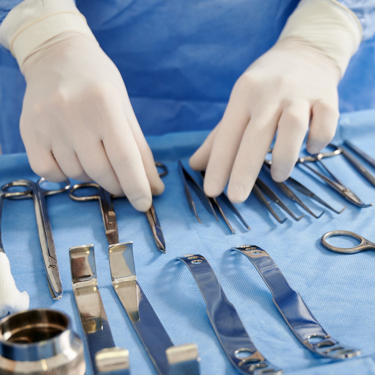 Doctor preparing instruments for plastic surgery in operating room.