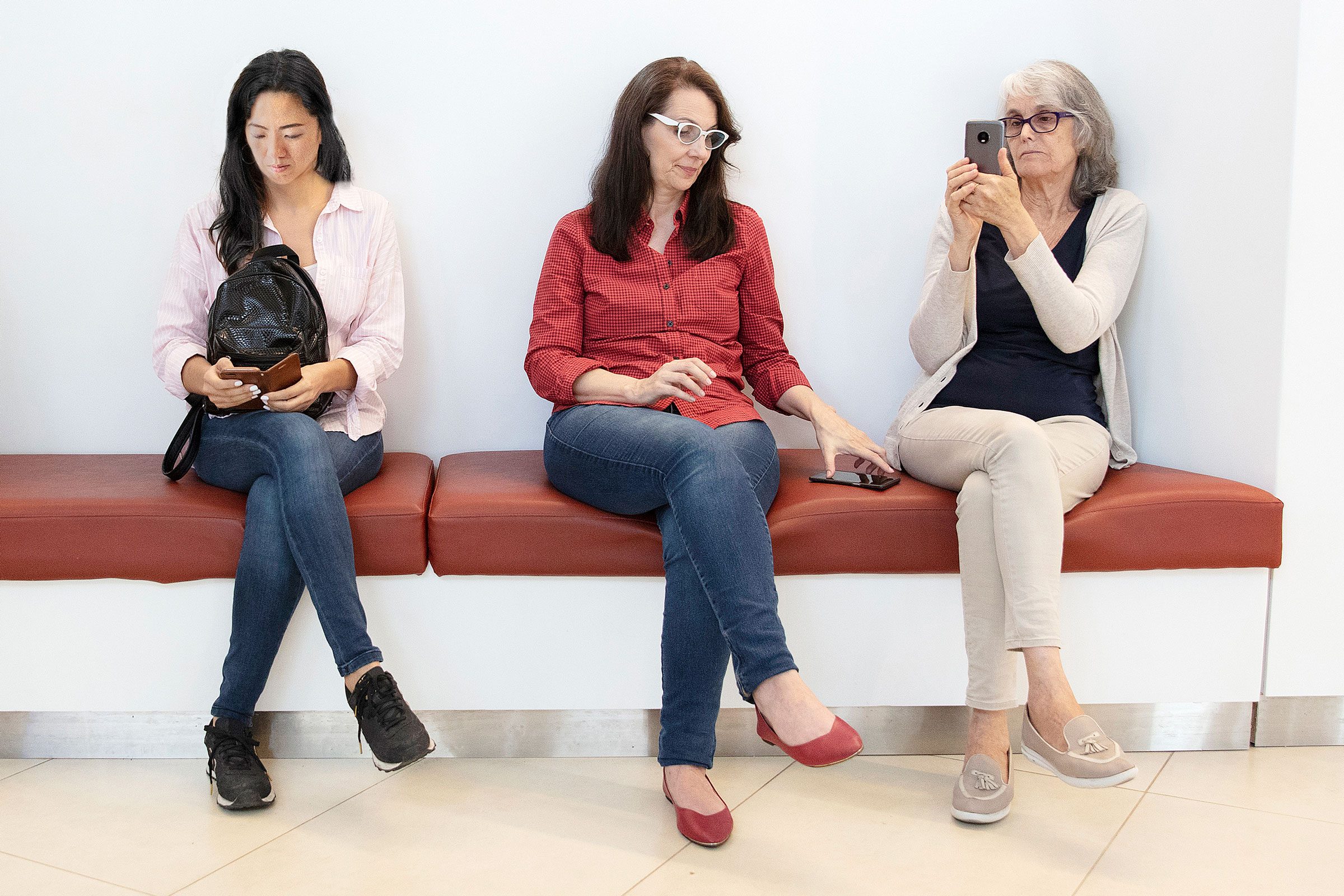 three women on a bench waiting at the doctors