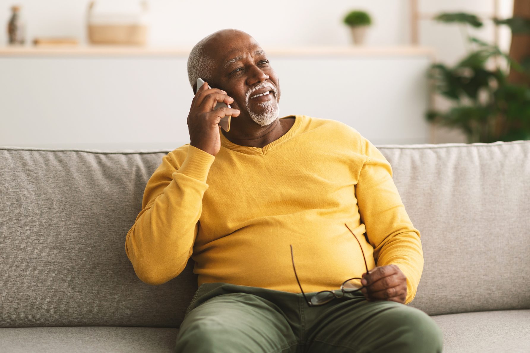 Senior African American Man Talking On Cellphone Sitting At Home