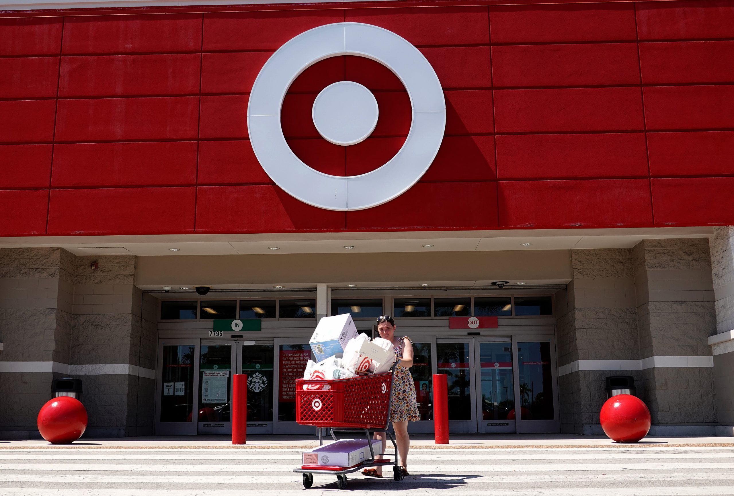 woman walking with full shopping cart at Target because of price drops