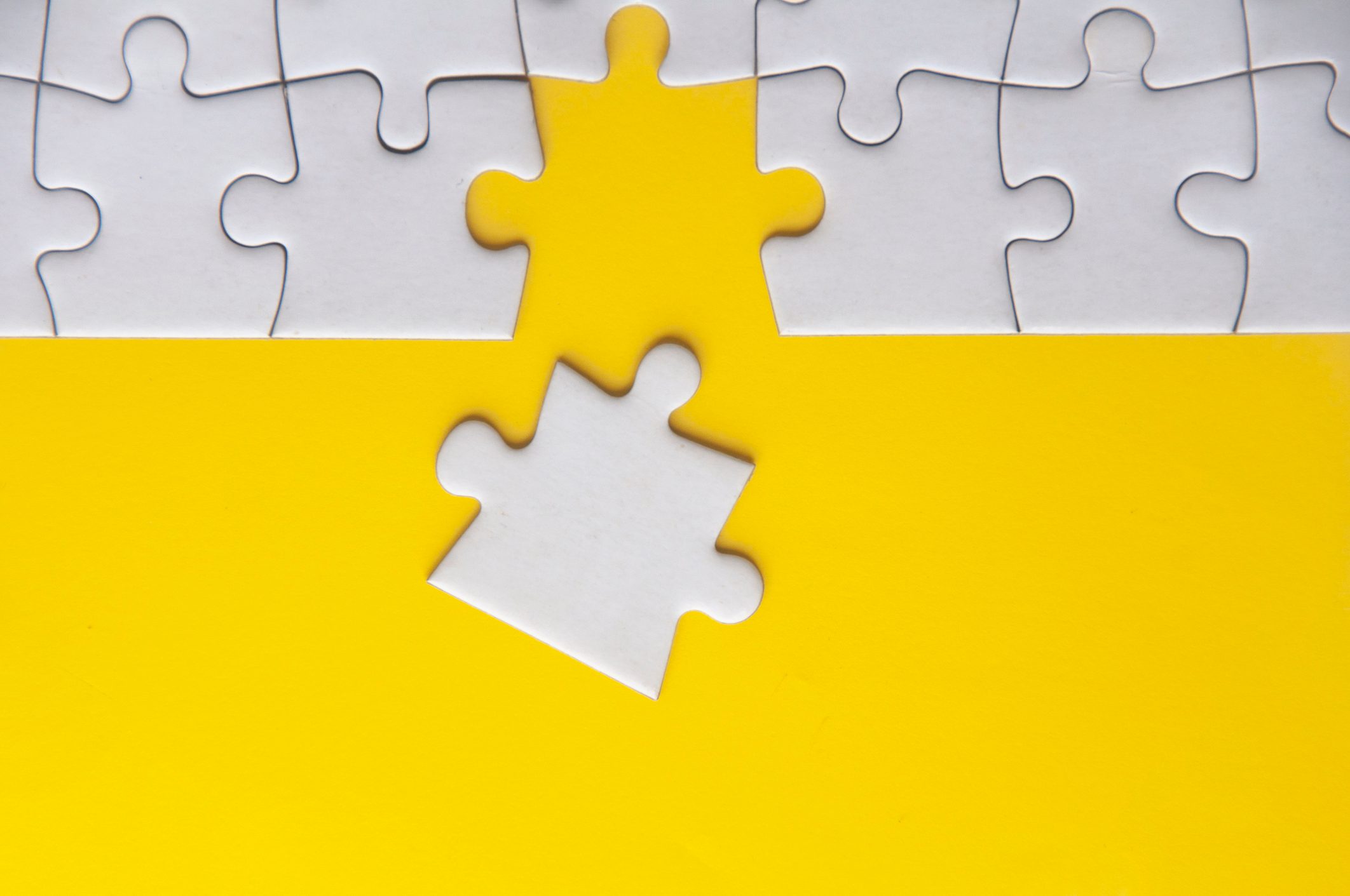 Top view of separated jigsaw puzzle with customizable space for text. Copy space with yellow background