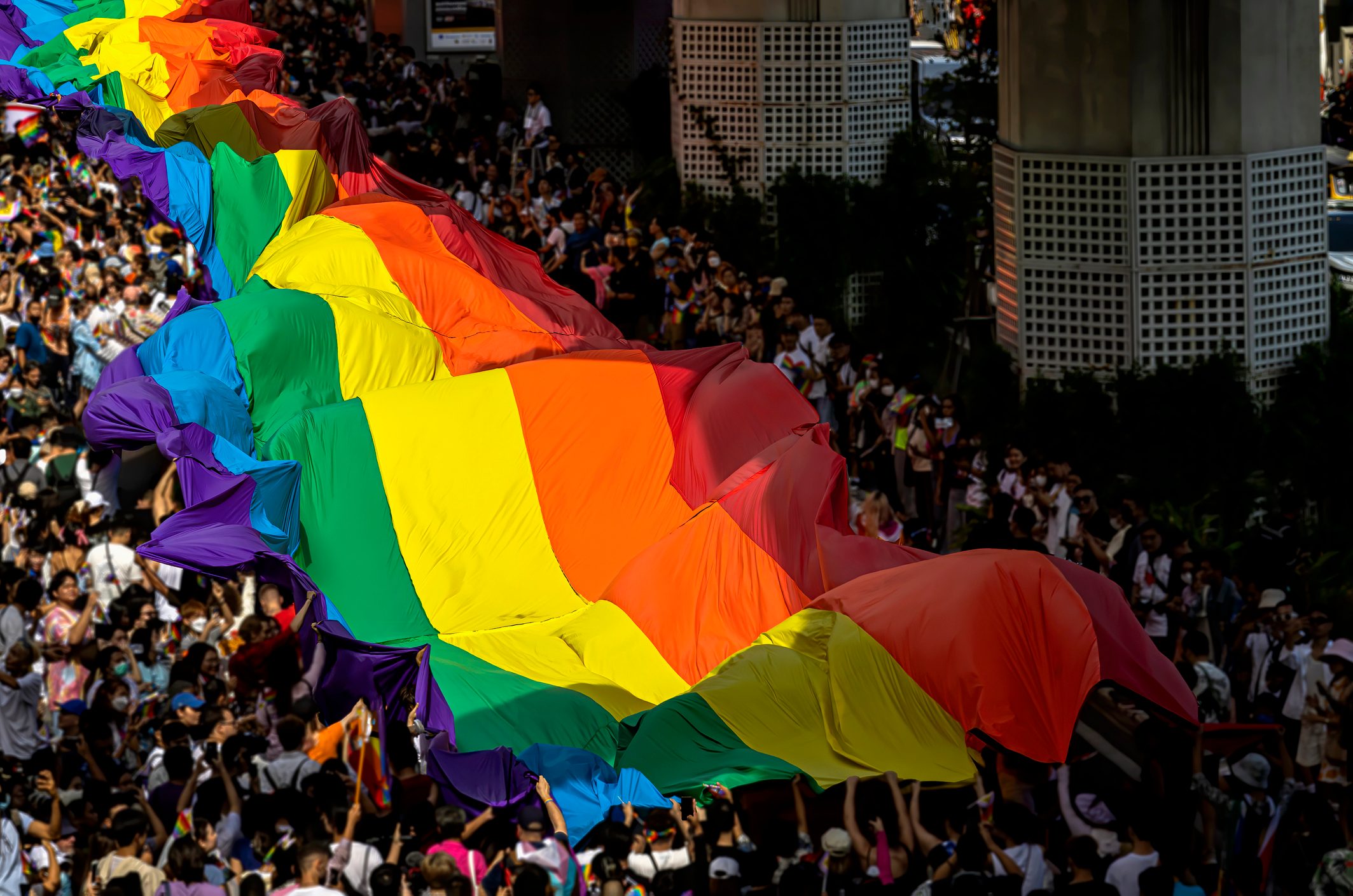 Group of people celebrating Pride Month and Parade-People marching with the rainbow LGBTQI flag