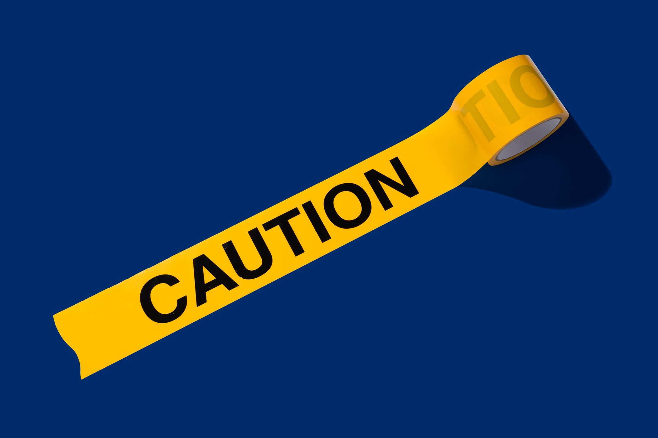 A Roll of Opened Caution Cordon Tape on Blue