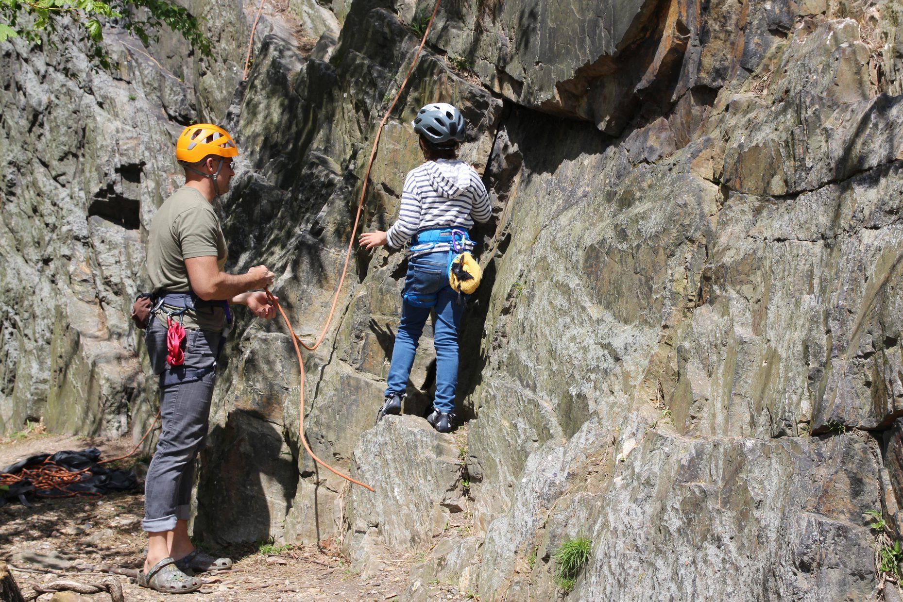 Dad setting up ropes for his daughter to rock climb