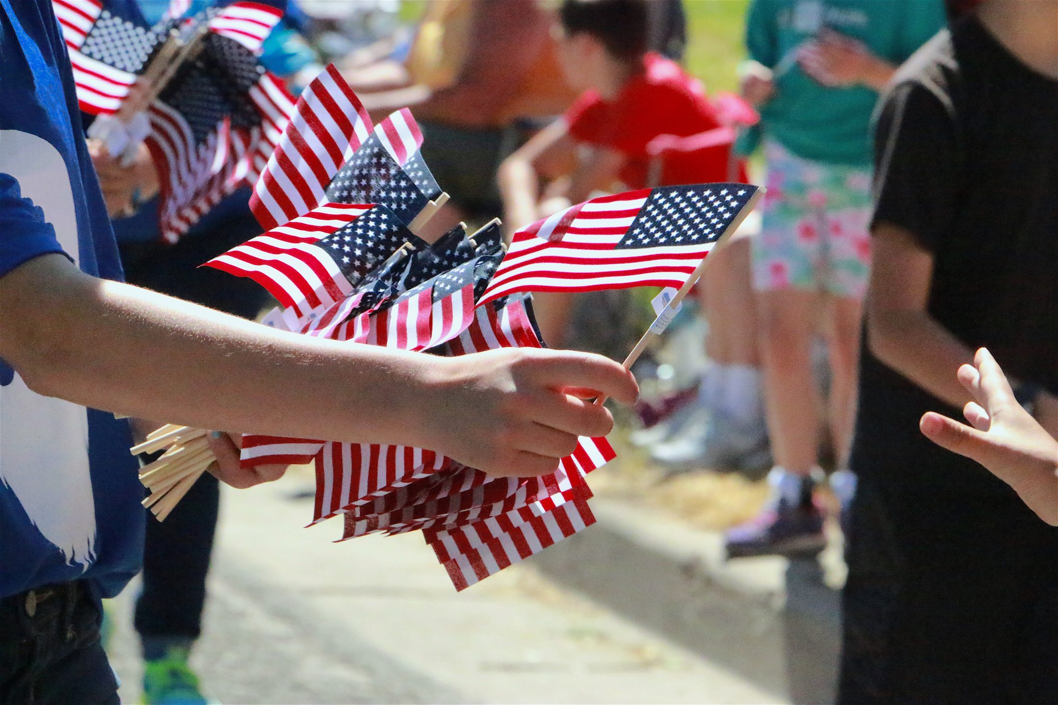 Hand Passing Out American Flags at a fourth of july Parade