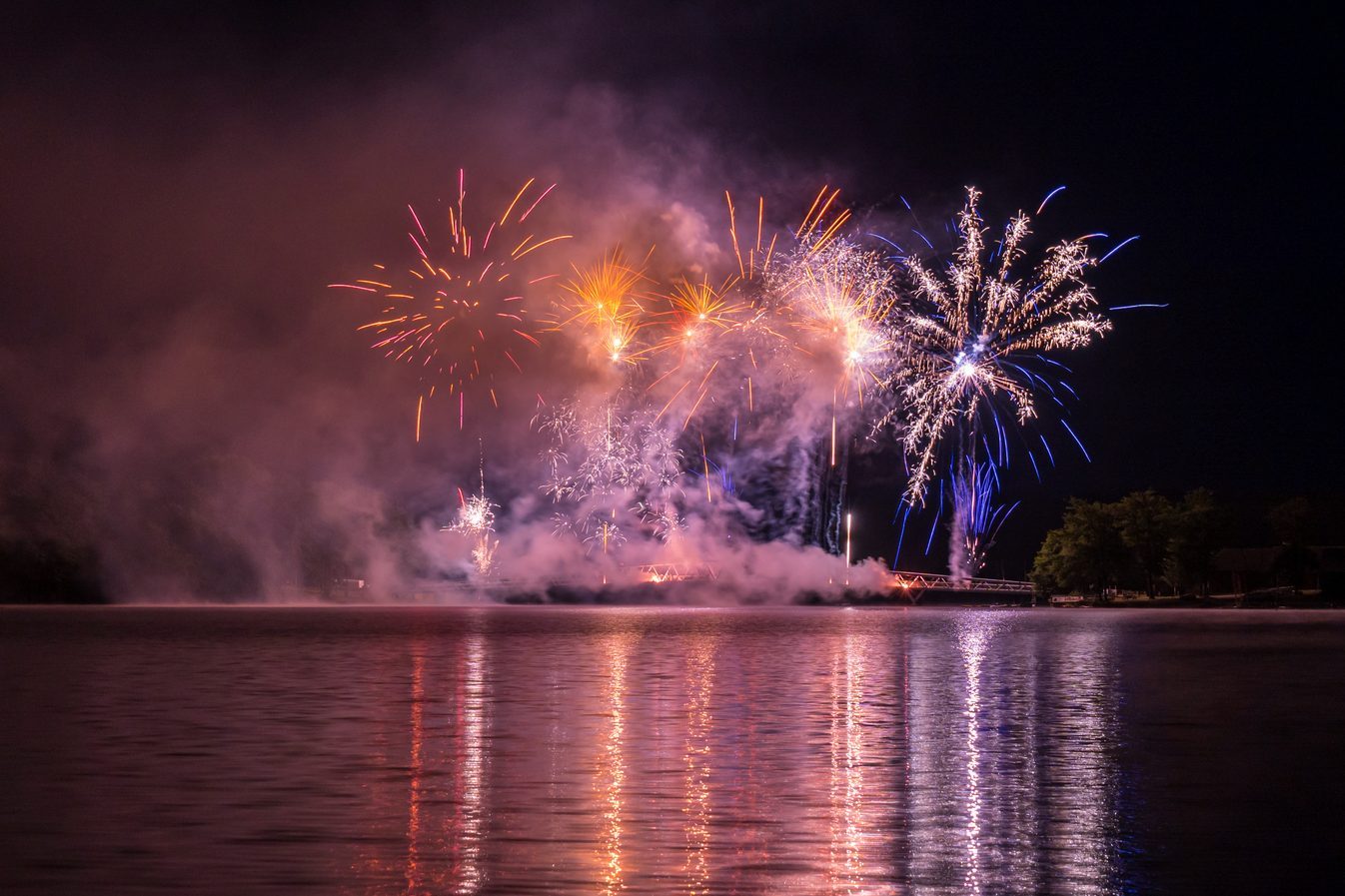 Firework 2023 12 July above bridge of Saint Pardoux Lake in Limousin, Haute vienne, France