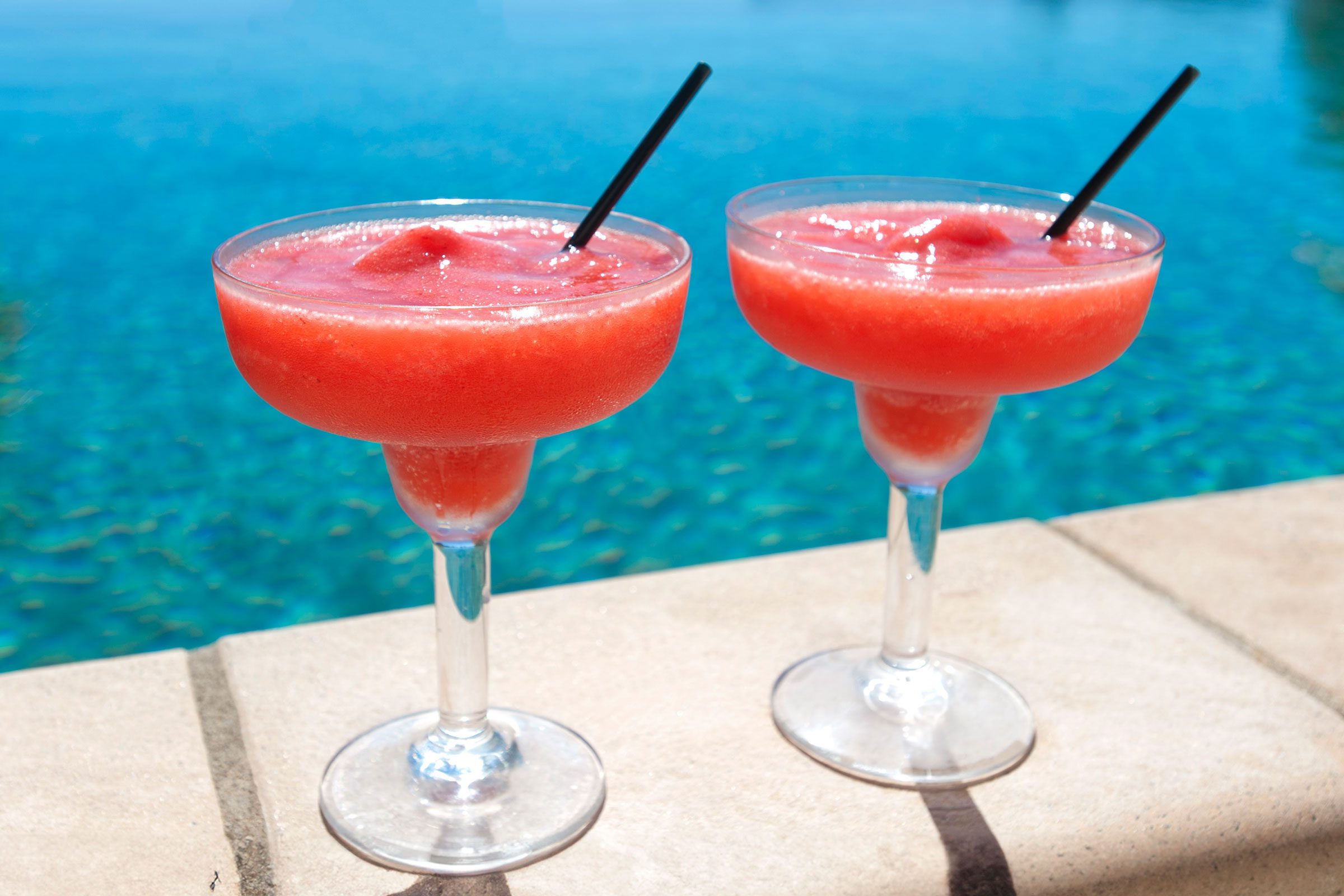 2 cocktails beside a resort swimming pool