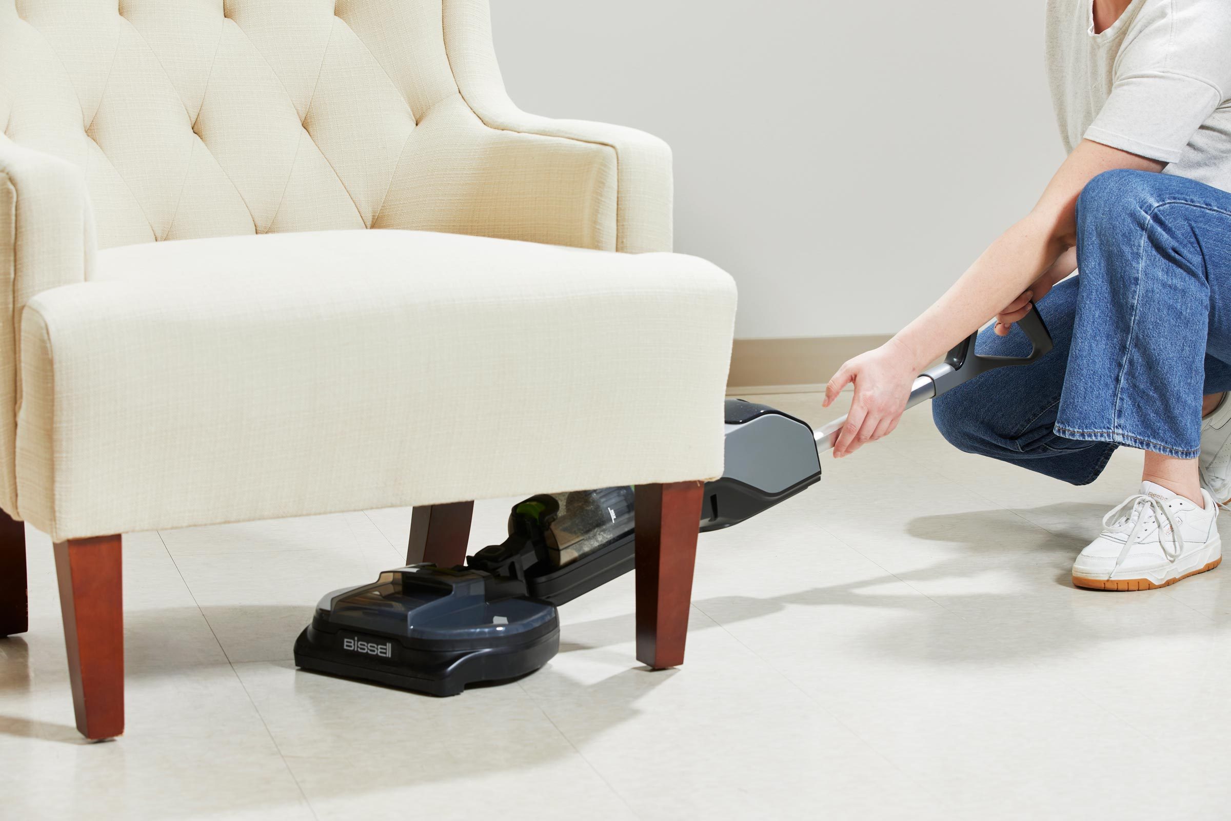 Bissell SpinWave vacuuming under a chair