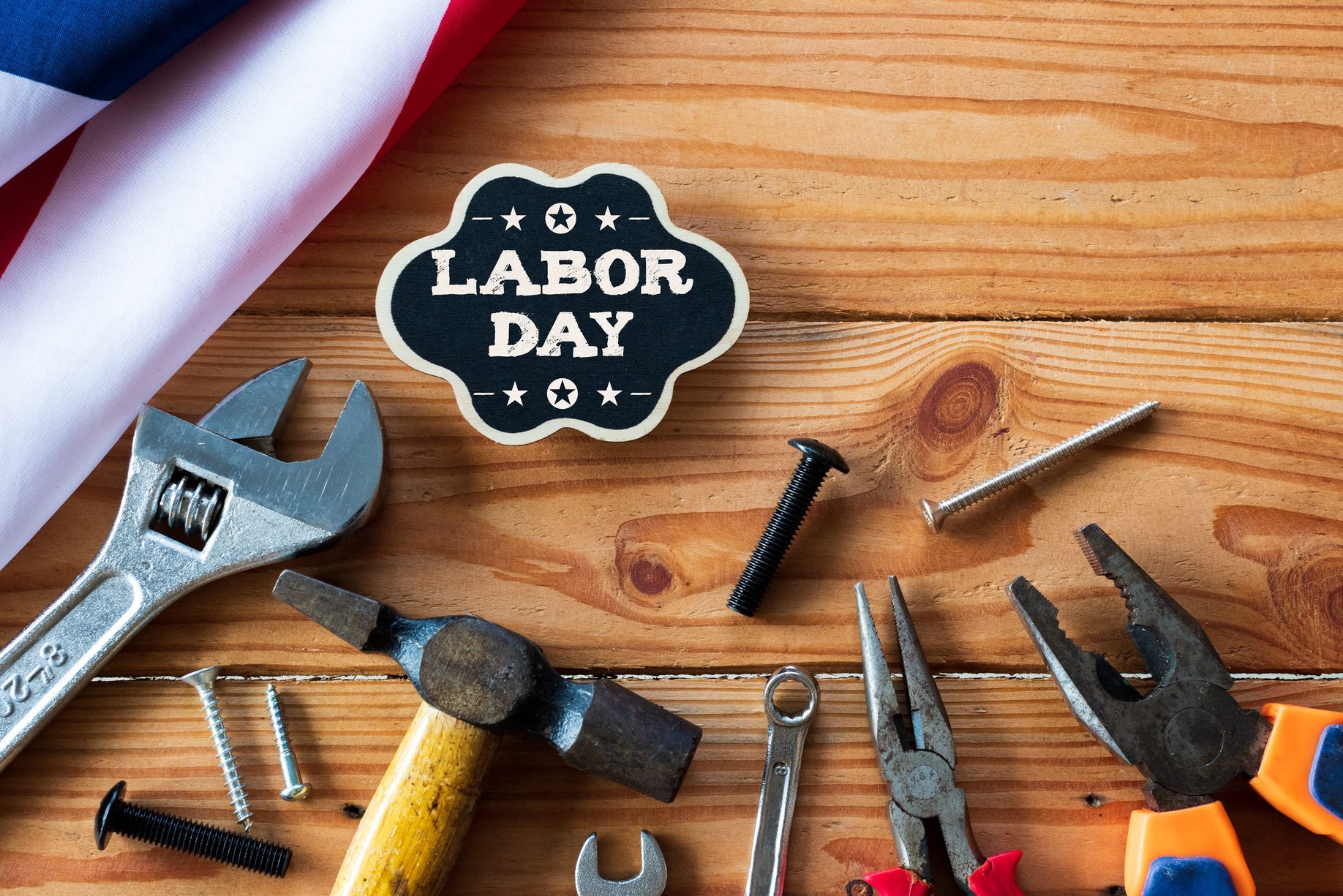 USA Labor day concept, First Monday in September. Different kinds on wrenches, handy tools, America flag and wooden tag on wooden table.