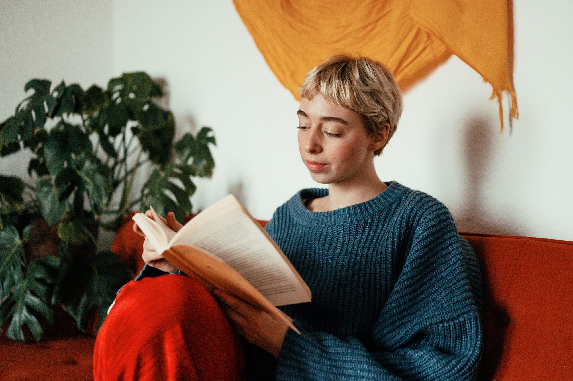Young Woman Reading A Book On A Couch