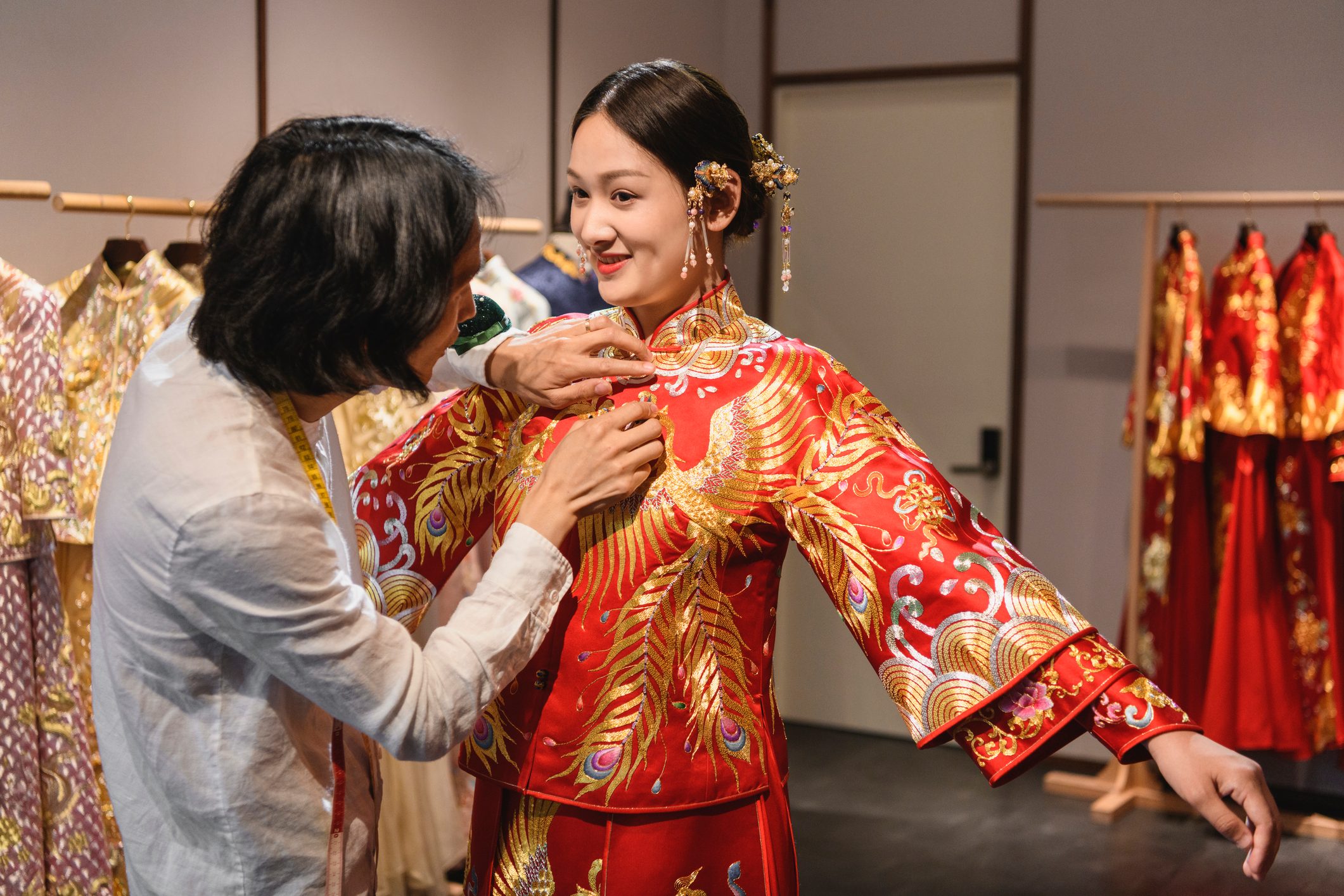 Male Chinese wedding dress designer fitting young bride