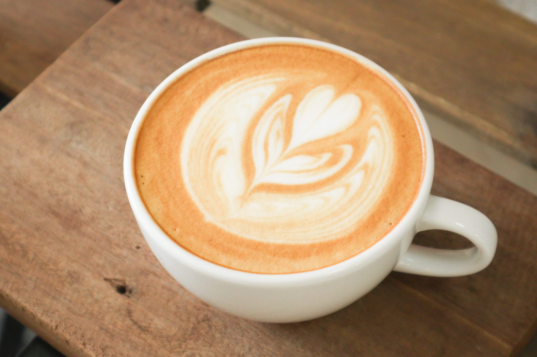 Coffee cup with latte art foam on wood table in coffee shop with copy space.Coffee is one of the most popular beverages.Improve Energy Levels and Burn Fat