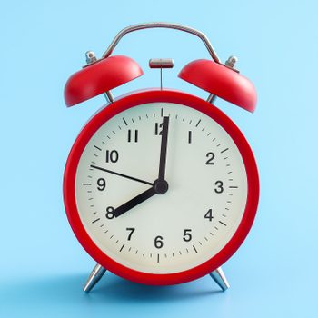 Red Retro Alarm Clock Isolated On A Blue Background